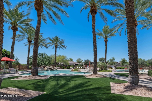 view of pool with a lawn