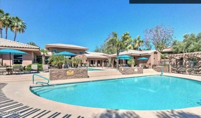 community pool with a pergola and a patio