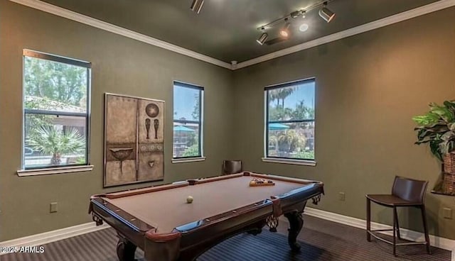 game room with ornamental molding, rail lighting, a healthy amount of sunlight, and baseboards