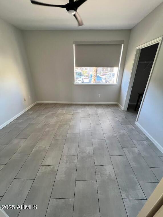 unfurnished room with baseboards and a ceiling fan