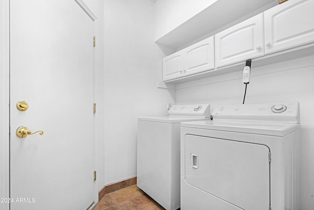 washroom with cabinets and washing machine and dryer