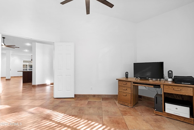 tiled home office with ceiling fan and a towering ceiling