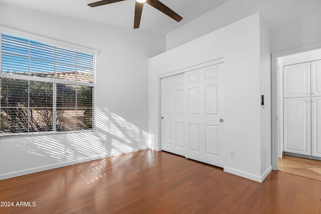 unfurnished bedroom featuring hardwood / wood-style flooring, ceiling fan, and a closet