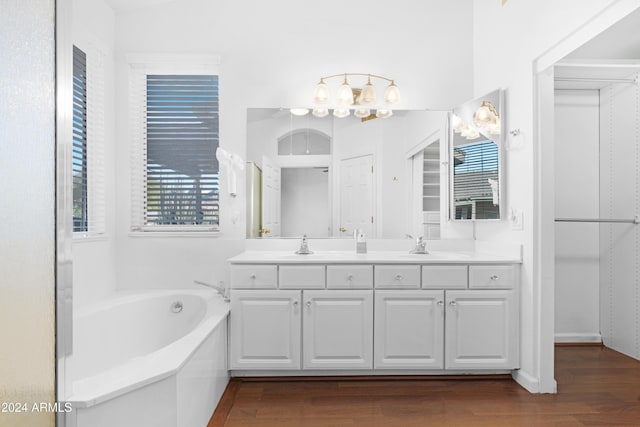 bathroom featuring hardwood / wood-style flooring, vanity, and a tub