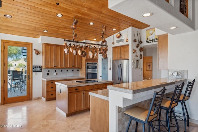 kitchen featuring wooden ceiling, a kitchen breakfast bar, vaulted ceiling, kitchen peninsula, and stainless steel appliances