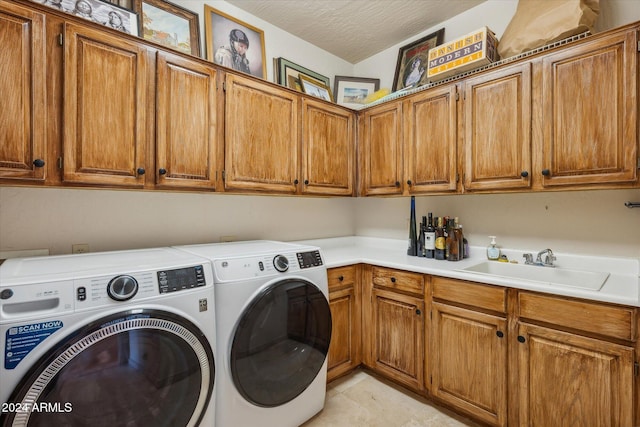 washroom with washer and clothes dryer, cabinets, a textured ceiling, and sink