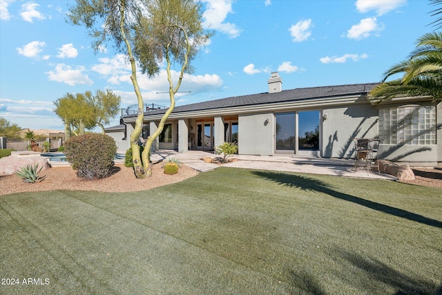25210 N 90th Way, Scottsdale, AZ 85255 - rear view of house featuring a patio, stucco siding, a chimney, and a yard