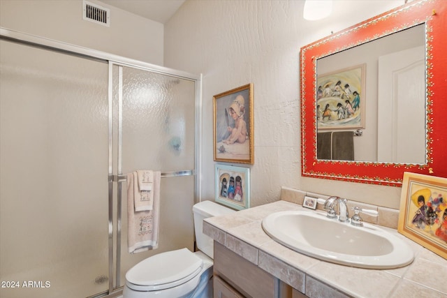 bathroom with vanity, an enclosed shower, and toilet