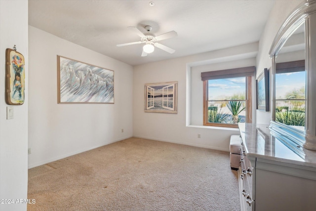 spare room featuring light colored carpet and ceiling fan