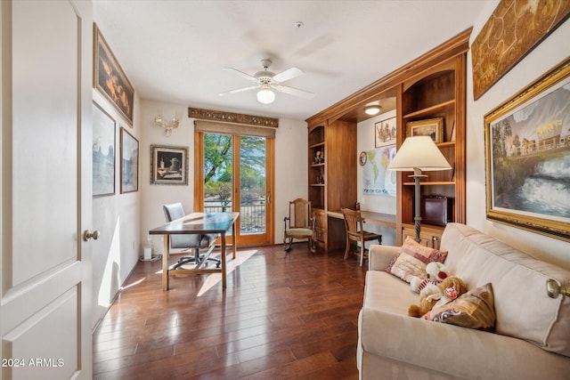 office area with built in shelves, ceiling fan, and dark hardwood / wood-style flooring