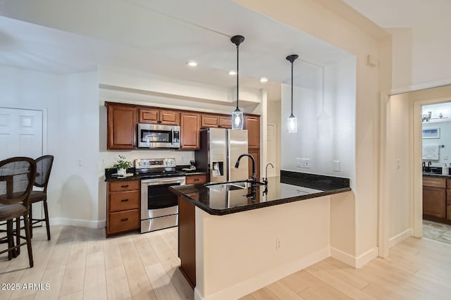 8653 E Royal Palm Rd Unit 1030, Scottsdale, AZ 85258 - kitchen with stainless steel appliances, light wood-type flooring, a peninsula, pendant lighting, and recessed lighting