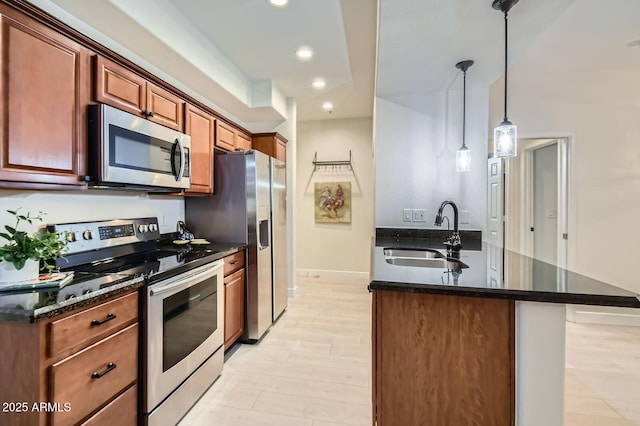 8653 E Royal Palm Rd Unit 1030, Scottsdale, AZ 85258 - kitchen with stainless steel appliances, recessed lighting, dark stone counters, decorative light fixtures, and a peninsula