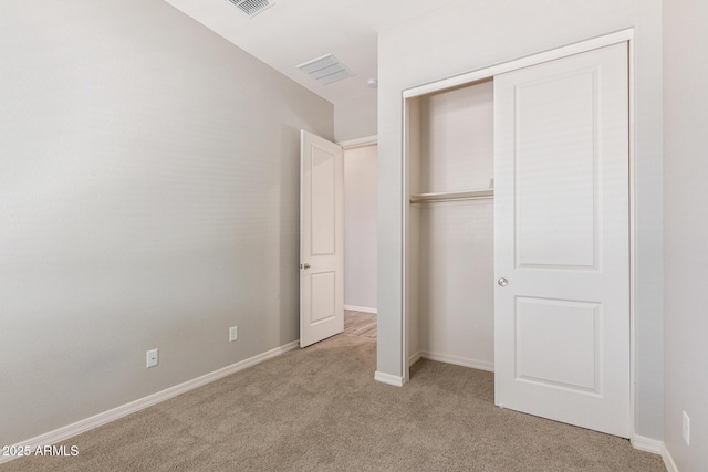 unfurnished bedroom featuring a closet, carpet flooring, visible vents, and baseboards