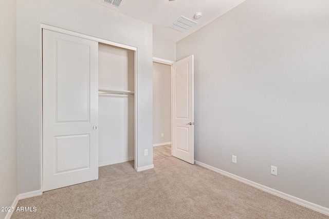 unfurnished bedroom featuring carpet floors, a closet, visible vents, and baseboards