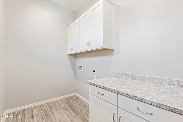 laundry room featuring cabinet space, baseboards, wood finish floors, washer hookup, and electric dryer hookup