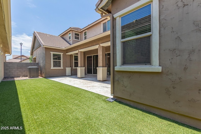 rear view of property featuring fence, cooling unit, a patio, and stucco siding