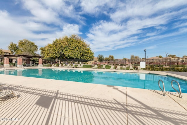 community pool featuring fence and a patio