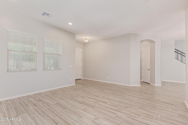 empty room featuring recessed lighting, visible vents, stairway, light wood-type flooring, and baseboards