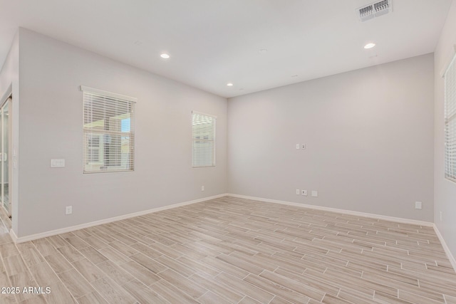 unfurnished room with wood tiled floor, visible vents, baseboards, and recessed lighting