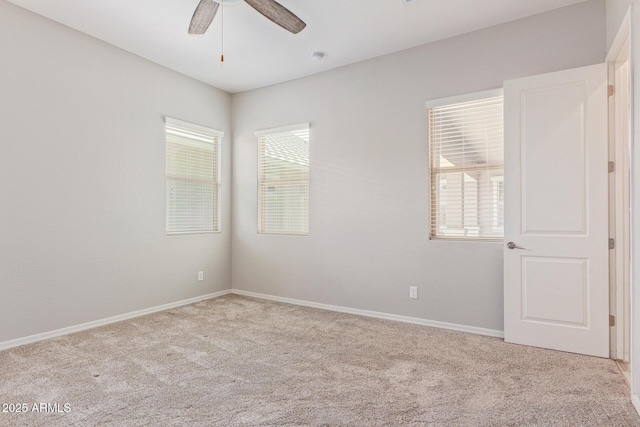 empty room with carpet floors, ceiling fan, and baseboards