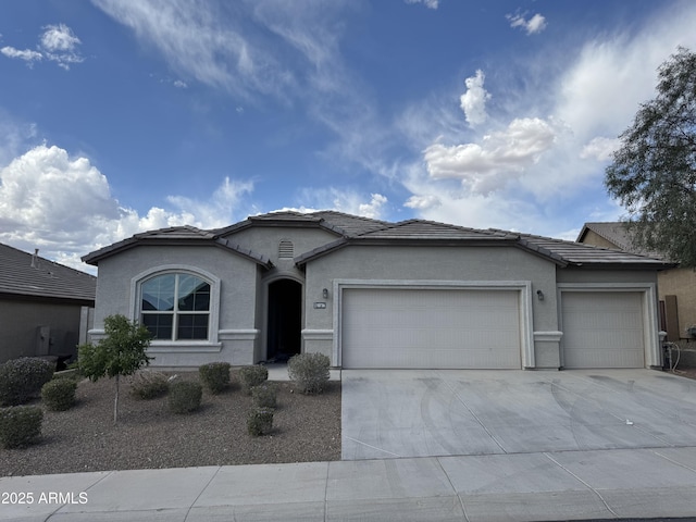ranch-style home featuring stucco siding, driveway, a tile roof, and a garage
