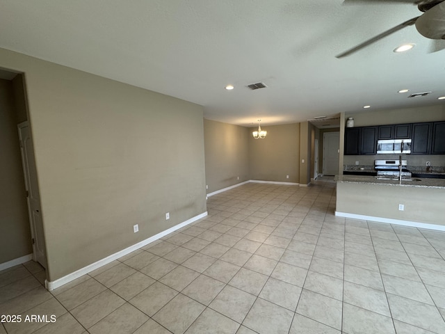 unfurnished living room with visible vents, recessed lighting, ceiling fan with notable chandelier, and light tile patterned floors