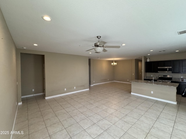 interior space featuring recessed lighting, baseboards, a sink, and ceiling fan with notable chandelier