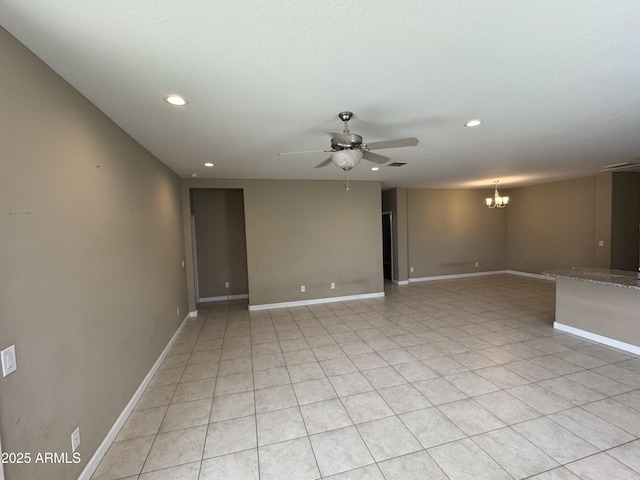 empty room with recessed lighting, baseboards, light tile patterned floors, and ceiling fan with notable chandelier