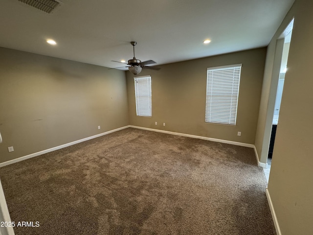 empty room with carpet, a ceiling fan, recessed lighting, and visible vents