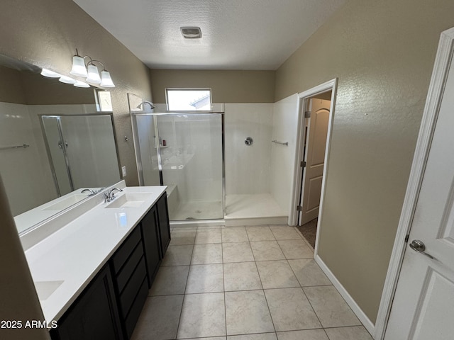 full bath featuring a textured wall, a sink, double vanity, a textured ceiling, and a shower stall