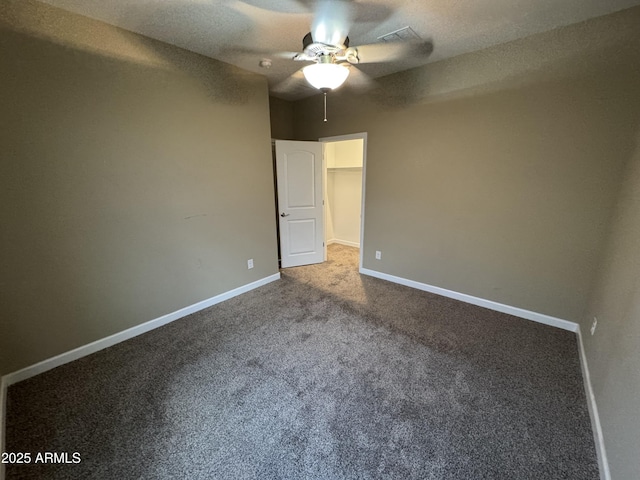 unfurnished bedroom with baseboards, visible vents, a walk in closet, and carpet