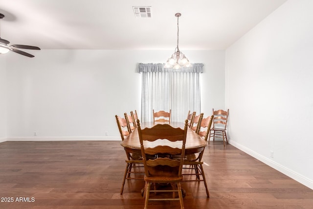 dining room with dark wood-style floors, ceiling fan with notable chandelier, visible vents, and baseboards