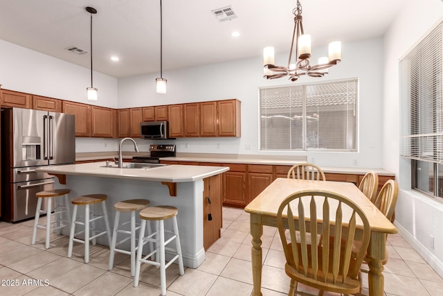 kitchen featuring a sink, stainless steel appliances, a notable chandelier, and visible vents