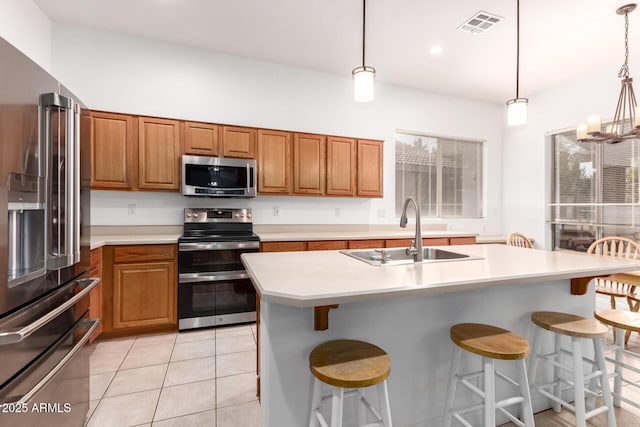 kitchen with a sink, brown cabinets, visible vents, and stainless steel appliances