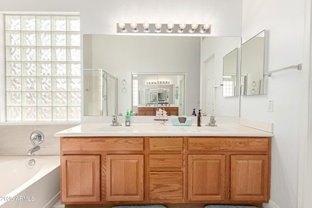 bathroom featuring a sink, a garden tub, double vanity, and a shower stall