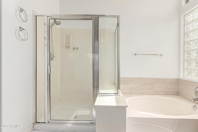 bathroom with a shower stall and a garden tub