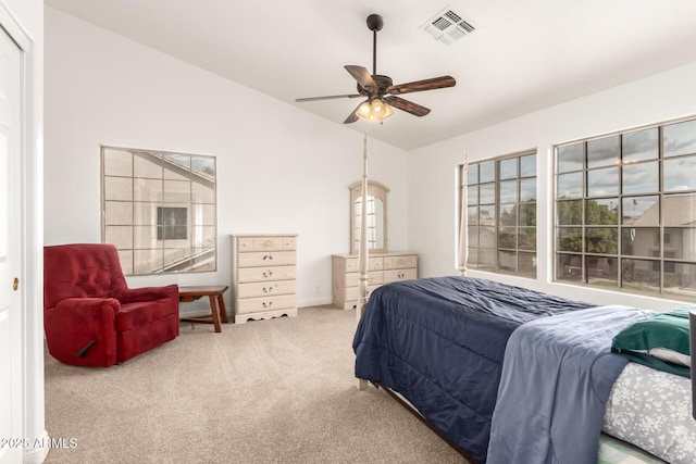 carpeted bedroom with vaulted ceiling, a ceiling fan, and visible vents