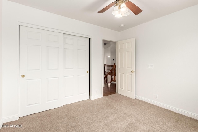 unfurnished bedroom featuring a ceiling fan, carpet flooring, baseboards, and a closet