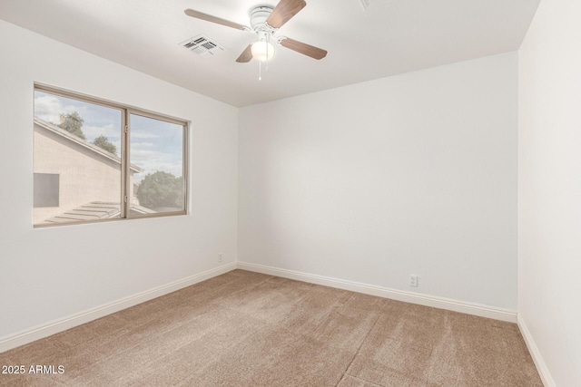 empty room with visible vents, light colored carpet, baseboards, and ceiling fan