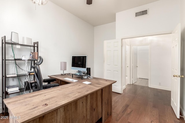 office featuring baseboards, dark wood-style floors, visible vents, and ceiling fan