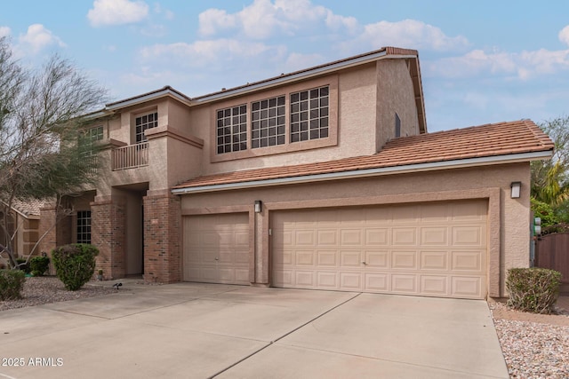 traditional home with brick siding, stucco siding, an attached garage, and concrete driveway