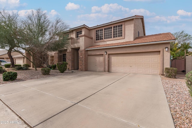 view of front facade with stucco siding, concrete driveway, an attached garage, and a tile roof