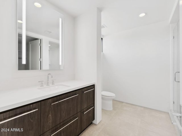 bathroom featuring vanity, toilet, and a shower with shower door