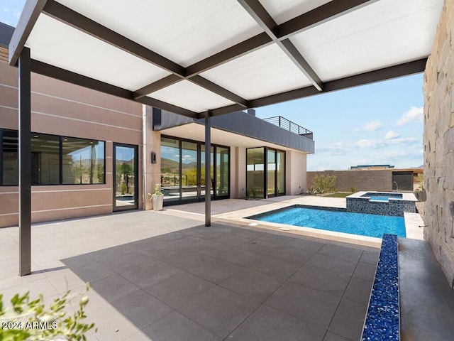 view of pool with an in ground hot tub and a patio