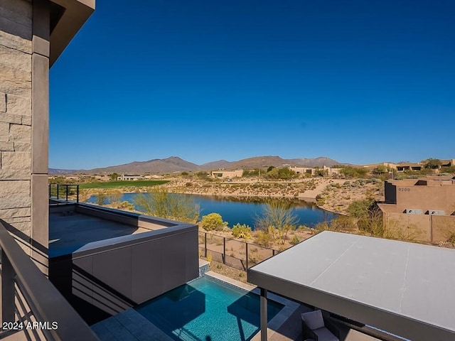 balcony featuring a water and mountain view