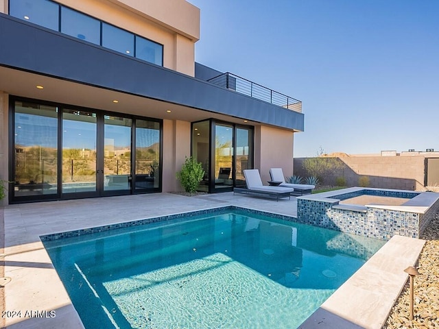 view of swimming pool featuring a patio area and an in ground hot tub