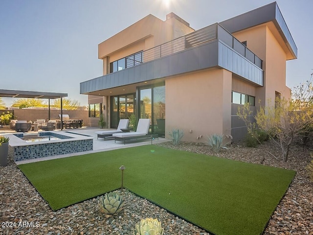 rear view of house with an outdoor living space, a patio area, and a balcony