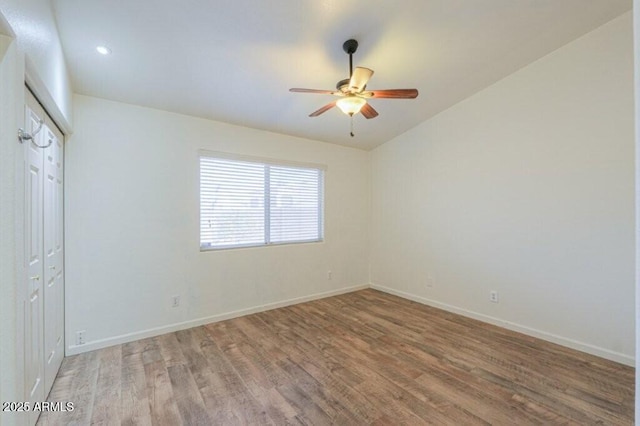 unfurnished room with recessed lighting, wood finished floors, a ceiling fan, and baseboards