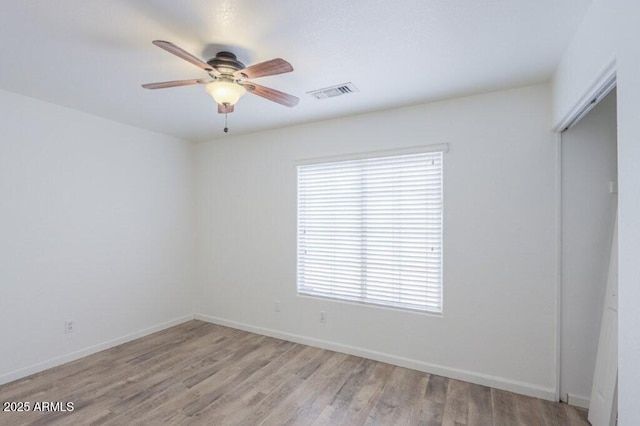 interior space featuring light wood-style floors, visible vents, baseboards, and a ceiling fan