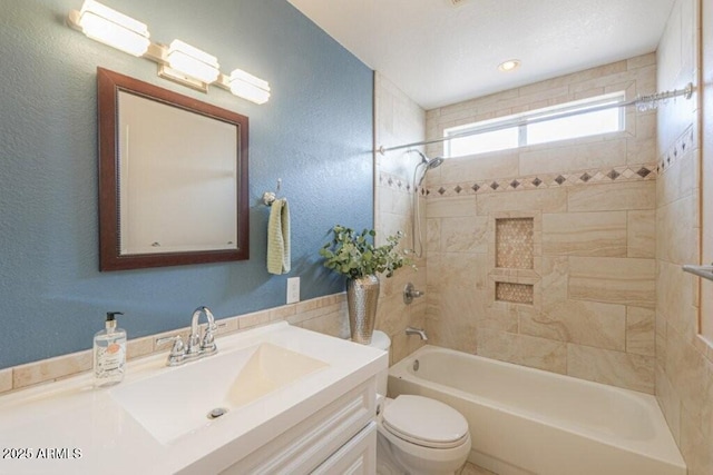 full bath featuring a textured wall, shower / bathing tub combination, vanity, and toilet